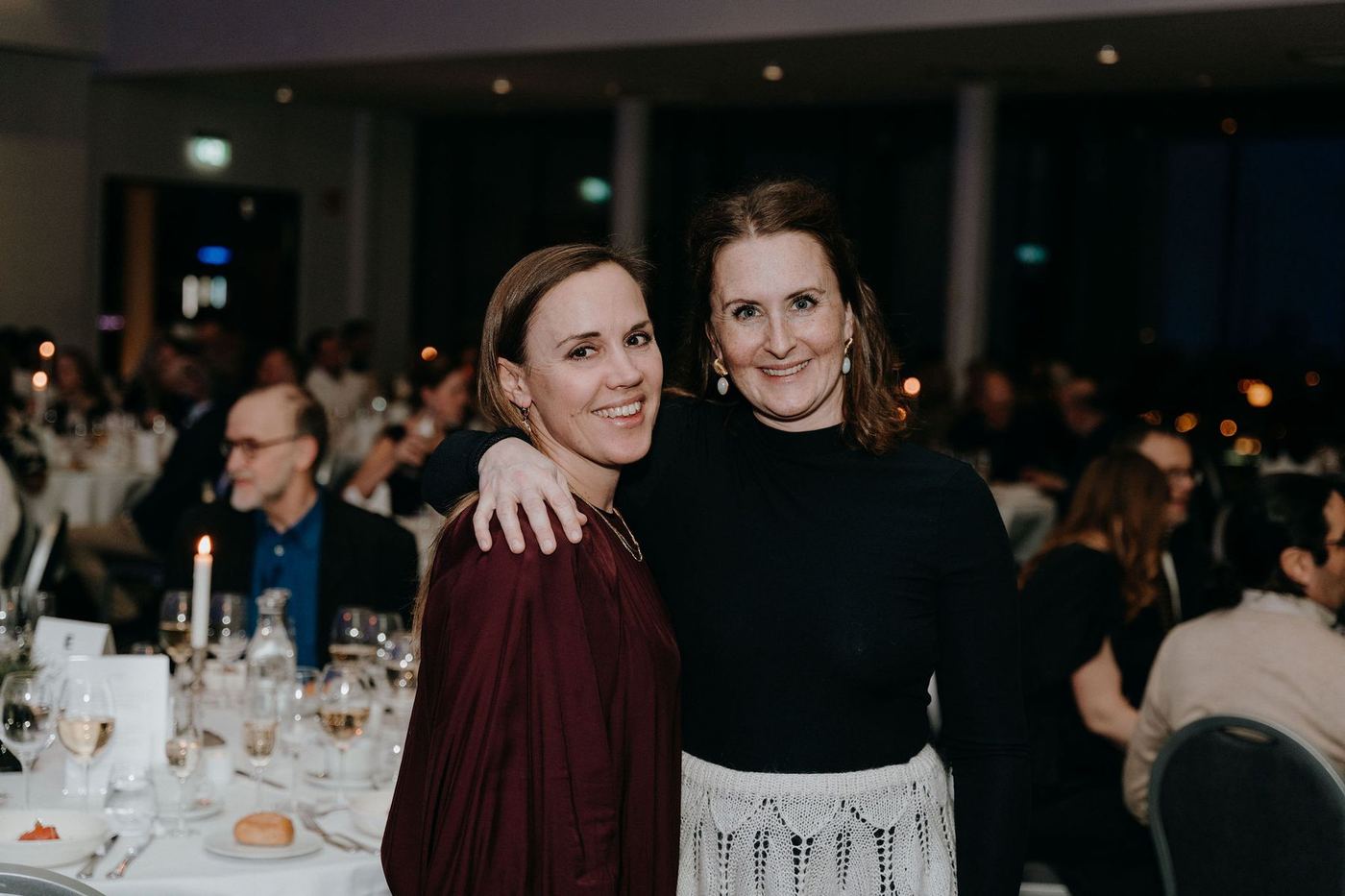 Två kollegor ler tillsammans vid festmiddagen på Distriktsläkarstämman 2025